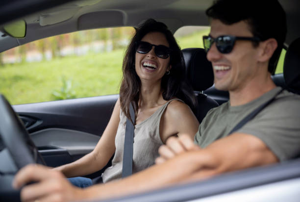Happy couple going on a romantic getaway by car