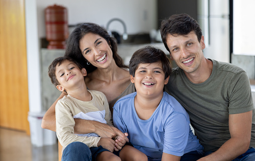 Portrait of a happy Brazilian family smiling at home and looking at the camera - lifestyle concepts