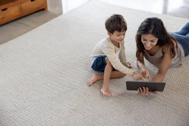 Photo of Mother and son watching funny videos online on a tablet