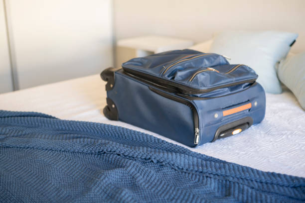 istock Carry-on luggage on  bed at hotel room 1385877201