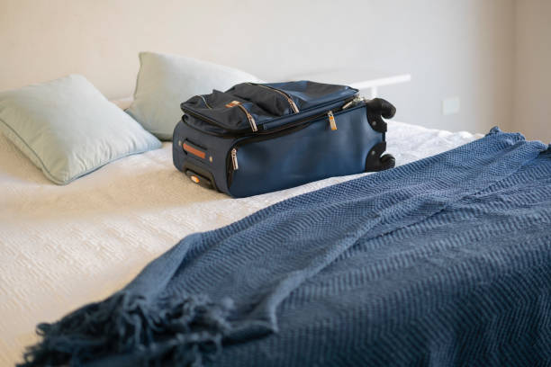 istock Carry-on luggage on  bed at hotel room 1385877228