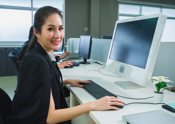 istock beautiful women worker happy using computer in office workplace 1385878093