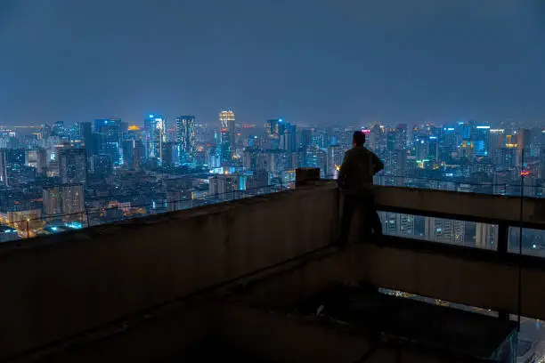 Photo of A man who looks at the scenery at high altitude at night