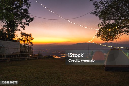 istock Tourist tents at dusk as the sky glows orange before sunset. 1385899877