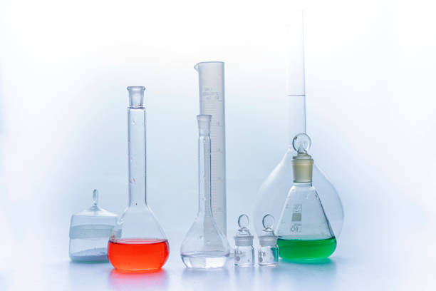 Photo Laboratory glass flasks with multicolored liquid isolated on white