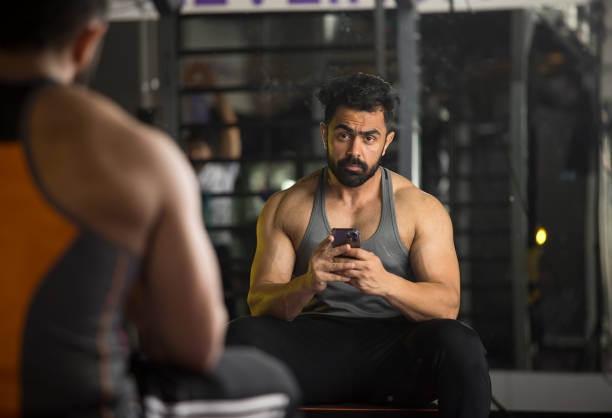 istock Man photographing using mobile phone at gym 1385903946