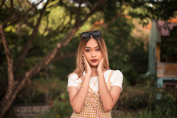 A young asian woman in casual summer wear at the park during the afternoon. Wearing blue gray contact lens A young asian woman in casual summer wear at the park during the afternoon. Wearing blue gray contact lens seduction stock pictures, royalty-free photos & images