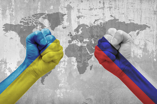 Ukraine and Russia Flag on hands punch