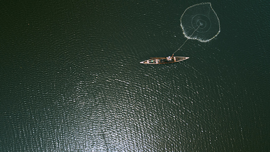 Victoria Island Lagos, Nigeria - 15 March 2022: Drone view of a fisherman on a fishing boat in Kuramo waters