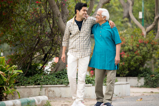 istock Cheerful old man with son having fun at park 1385908440