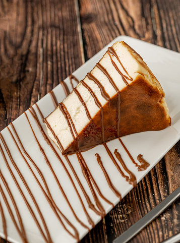 Sliced san sebastian cheesecake with coffee on wooden table