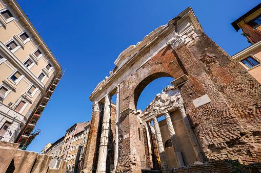The remains of the Roman Temple of Portico D'Ottavia (Porticus Octaviae) in the historic heart of the Eternal City, near the archeological area of the Theatre of Marcellus and the Jewish Ghetto. According to tradition and some archaeological remains of Ancient Rome this area was occupied by a fish market. The iconic Jewish Quarter of Rome, the oldest ghetto in Europe, is famous for the presence of hidden alleys and small squares, where it is easy to find small restaurants of Italian and Jewish cuisine, and remarkable Roman archaeological remains. The ghetto of Rome is located in one of the oldest districts of the Eternal City, located between the Campidoglio (Roman Capitol) and the Tiber river. In 1980 the historic center of Rome was declared a World Heritage Site by Unesco. Super wide angle image in high definition format.