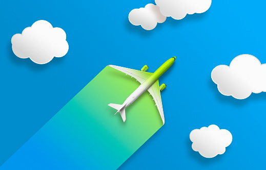 Green and white Aircraft with colorful contrail on blue background with clouds