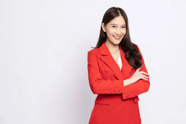 Photo of Portrait of successful business asian women in red suit with arms crossed and smile isolated over white background
