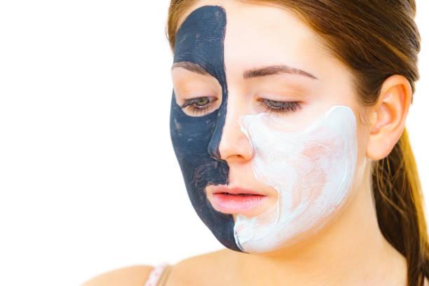 istock Girl black mask on half face apply white mud 1385920033
