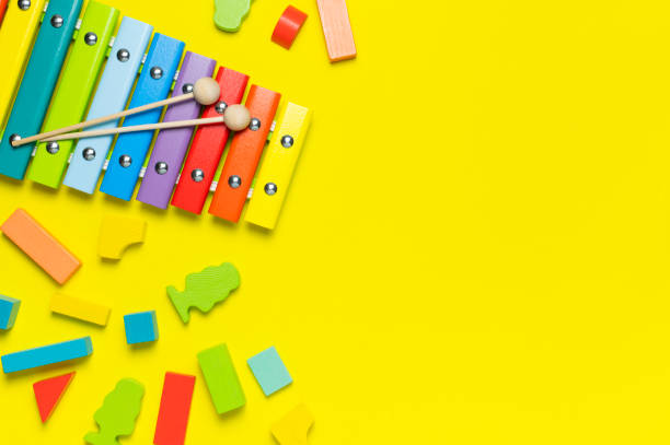 istock Multicolored wooden xylophone, wooden constructor on yellow background flat lay top view copy space. Wooden children's toy. Baby musical instrument. Colors of rainbow. Kids natural eco toys 1385920172
