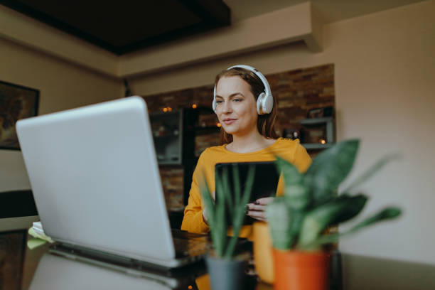 istock Woman using a laptop and a digital tablet working from home 1385920182