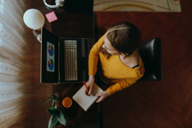 istock Woman using a laptop and working from home 1385920320