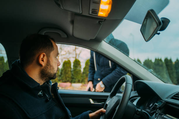 istock Armed bandit hijacking a middle-aged man's car. 1385920552