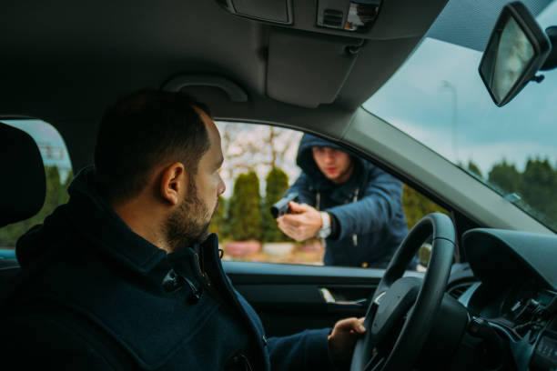 istock Armed bandit hijacking a middle-aged man's car. 1385920554