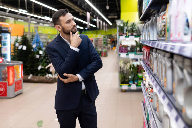istock man chooses engine oil for his car 1385921433