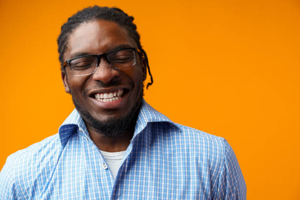 istock Handsome smiling young african man standing isolated over orange background 1385923660