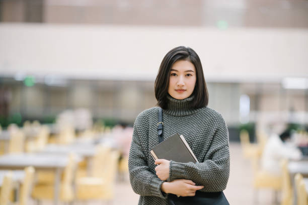 図書館で選抜図書を開催中のアジア女子学生 - bookstore student chinese ethnicity book ストックフォトと画像