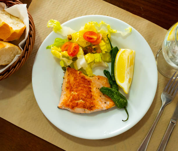 istock Salmon fillet with salad served on plate 1385928400