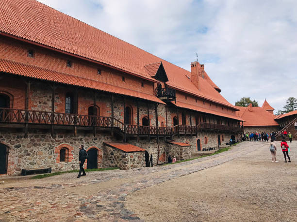 Trakai, Lithuania - August 10, 2019: Tourist family are enjoying pedal boat and a man rowing stand up paddle board  to sightseeing in the Lake Galve surrounding the Trakai Island Castle inTrakai, Lithuania