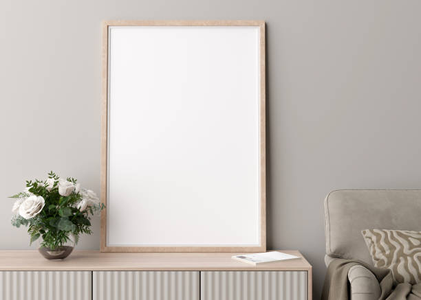 istock Empty vertical picture frame on cream wall in modern living room. Mock up interior in minimalist, scandinavian style. Free space for picture. Console, flowers in vase, armchair. 3D rendering. 1385933515