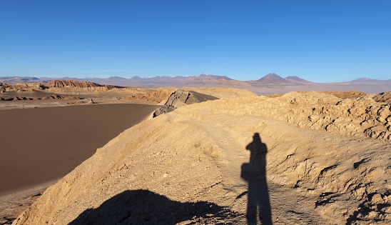 San Pedro de Atacama, Chile, December 2, 2018: View of the Moon Valley in Atacama desert with a photographer silhouette at sunset.