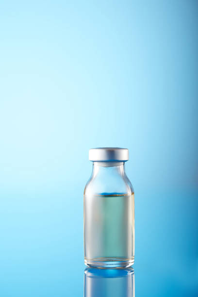 istock Vaccine injectable vials and syringe close up in blue tones 1385936113