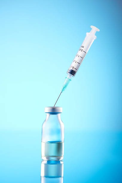 istock Syringe and Bottle on blue background 1385936118