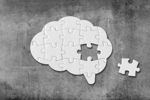istock Brain shaped white jigsaw puzzle on concrete wall background, a missing piece of the brain puzzle, mental health and problems with memory 1385936951