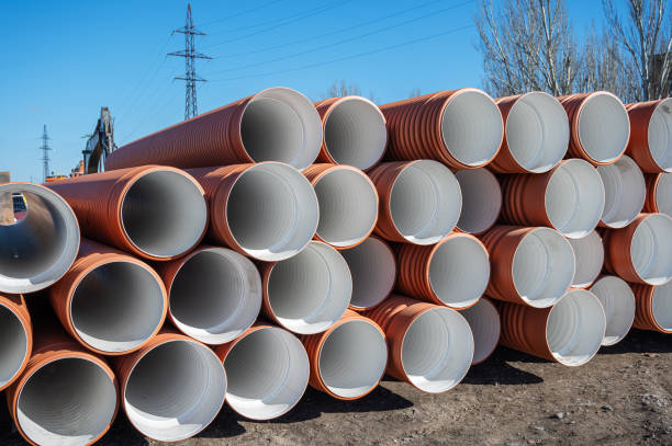 istock Stack of new orange polypropylene pipes outside. Plastic pipes for laying in the gutter. Industrial warehouse 1385941683
