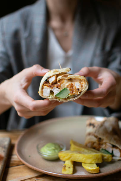 Close-up of hands holding a burrito