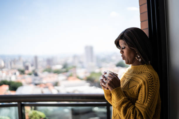 istock Woman drinking coffee or tea at apartment's balcony 1385944794