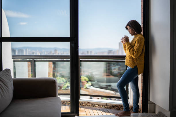 istock Woman drinking coffee or tea at apartment's balcony 1385944809