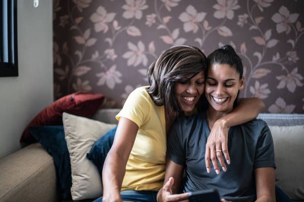 istock Lesbian couple using the mobile phone at home 1385945157