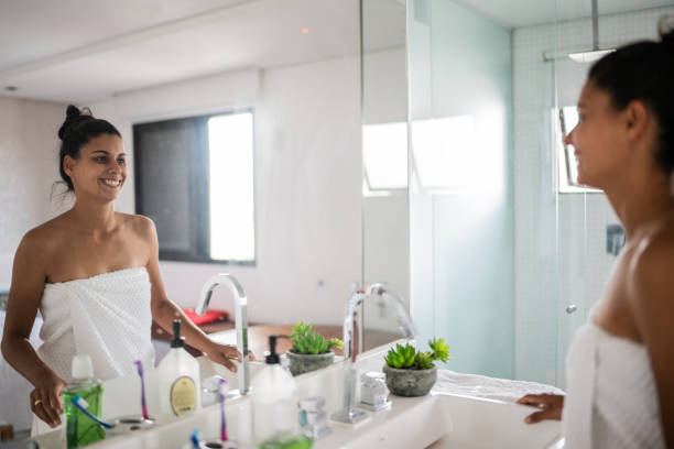 happy woman looking in the mirror at home - mirror vanity women looking imagens e fotografias de stock