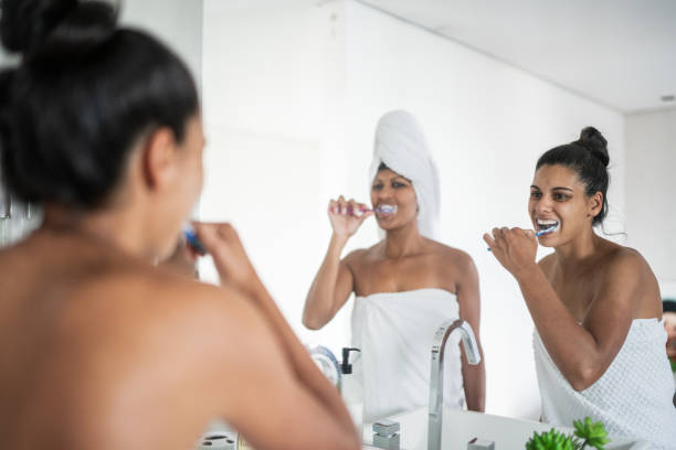 istock Female couple brushing teeth together 1385946328