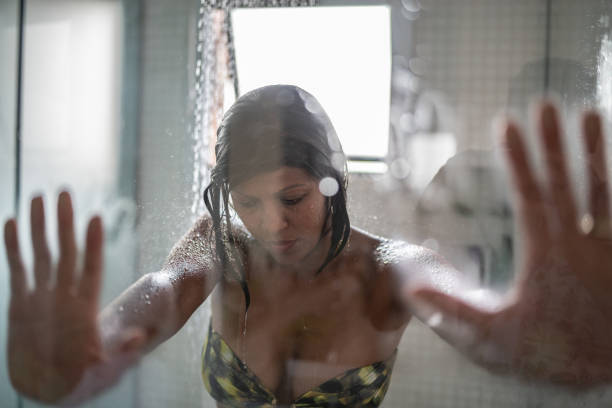 Sad woman taking a shower at home Sad woman taking a shower at home black woman washing hair stock pictures, royalty-free photos & images