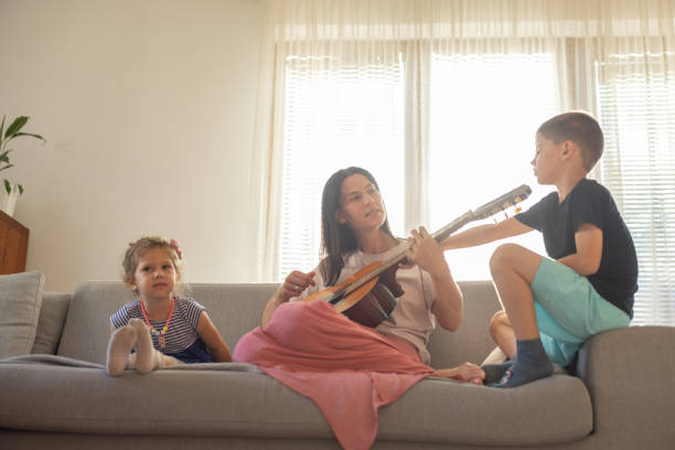 istock Mother and kids plays guitar 1385946835