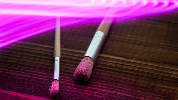 istock Two brush on wooden boards with purple abstract light 1385947032