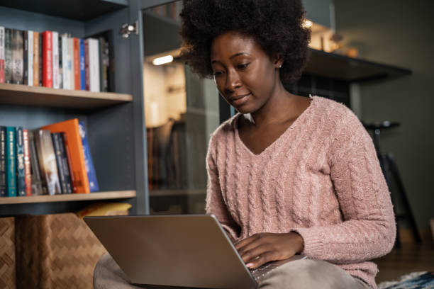 istock Young woman work on computer in the living room 1385948070