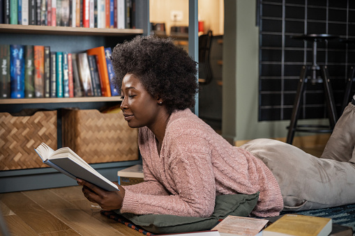 Young Woman Reading a Book in Bed Before Sleeping