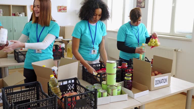 Multi-ethnic group of people packing donation boxes in charity food bank