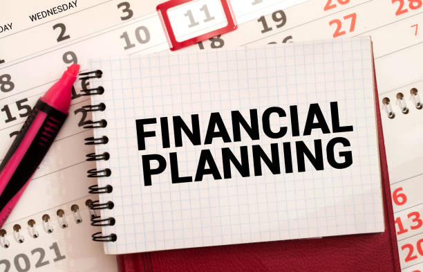 istock On a light blue background, reports, a magnifying glass, a pen and a notebook with the text FINANCIAL PLANNING. 1385955237