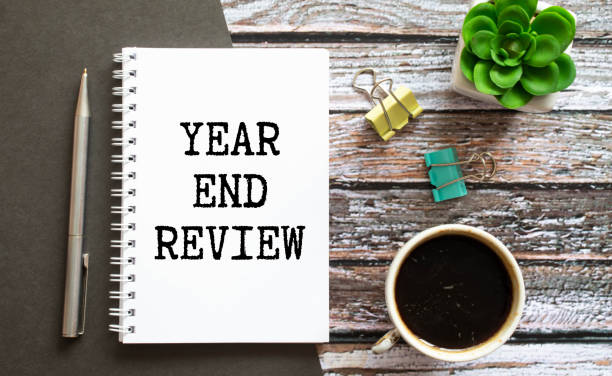 istock Selective focus of pencil,mobile phone and notebook written with Year End Review on white wooden background 1385955242