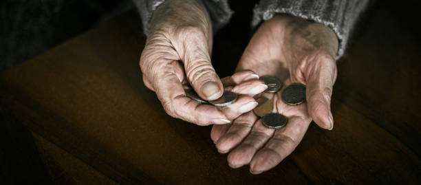 une retraitée compte de l’argent entre ses mains - women poverty senior adult mature adult photos et images de collection